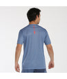 Camiseta de padel bullpadel chero en colores azul acero y blanco. Con logotipo en color naranja en pecho y manga. Vista de espalda.