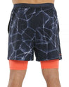 Pantalón corto de pádel bullpadel macheta color azul marino con estampado y logotipo en color naranja. Parte trasera.